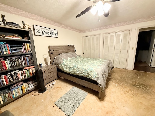 bedroom with two closets, unfinished concrete floors, and a ceiling fan