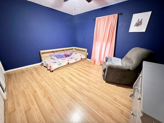 bedroom featuring a ceiling fan, wood finished floors, and baseboards