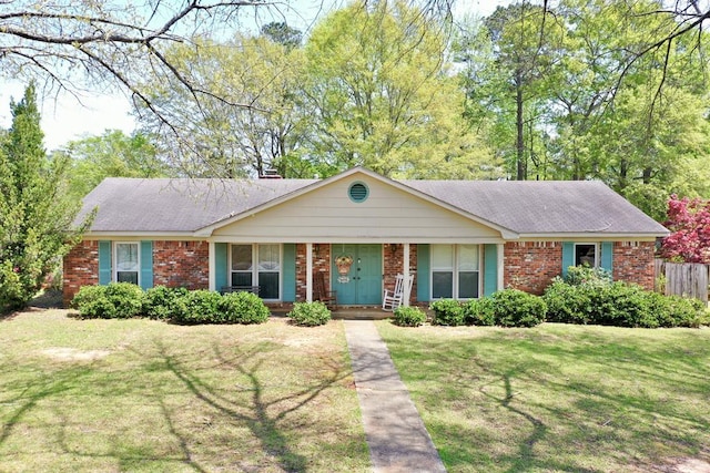 ranch-style house featuring brick siding, fence, a front yard, and a porch