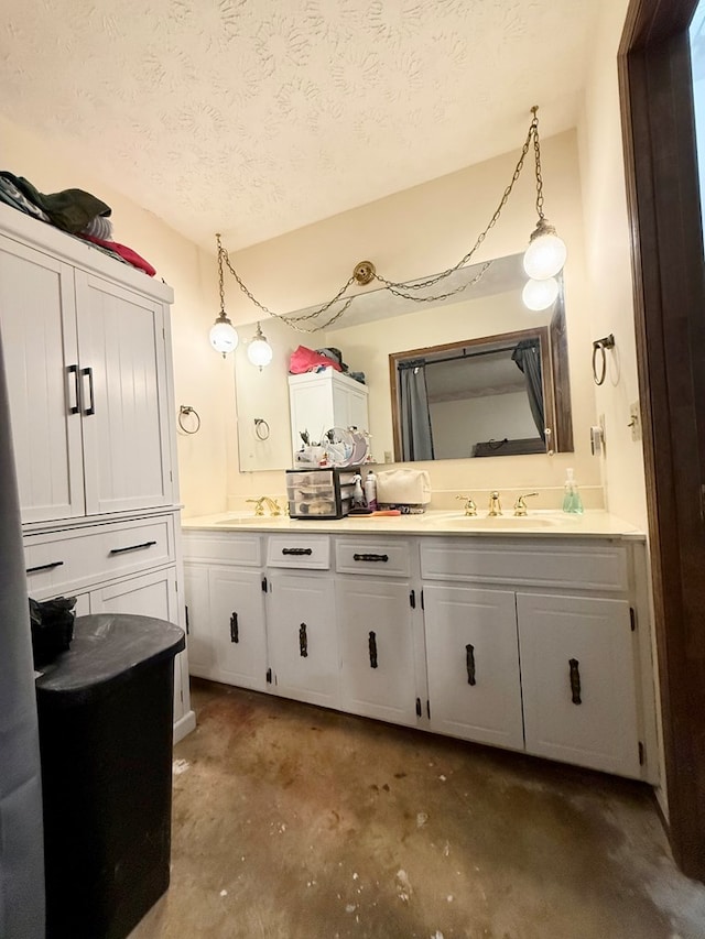 bathroom featuring a sink, double vanity, a textured ceiling, and concrete floors