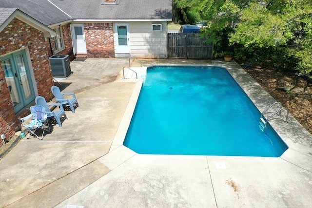 view of pool with a patio area, fence, french doors, a fenced in pool, and cooling unit