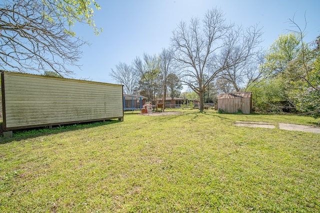 1043 Quincy Dr, Columbus, GA 31906 - view of green lawn with a trampoline and a storage shed