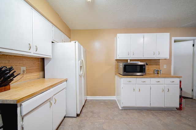 1043 Quincy Dr, Columbus, GA 31906 - kitchen featuring stainless steel microwave, white fridge with ice dispenser, decorative backsplash, light countertops, and white cabinets
