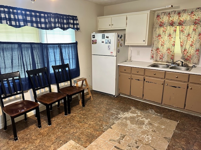 1103 52nd St, Columbus, GA 31904 - kitchen with freestanding refrigerator, a sink, dark stone finish flooring, and light countertops
