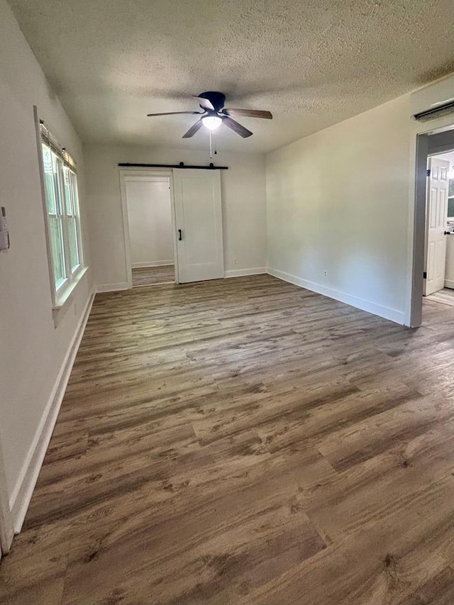 4026 Bowman St, Columbus, GA 31903 - spare room with a barn door, wood finished floors, a textured ceiling, and a ceiling fan