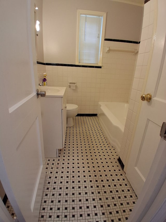 952 N Ave, Macon, GA 31211 - full bathroom featuring tile walls, vanity, a bath, toilet, and wainscoting