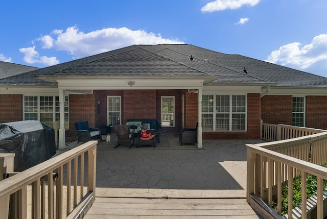 deck with an outdoor living space, a grill, and a patio area