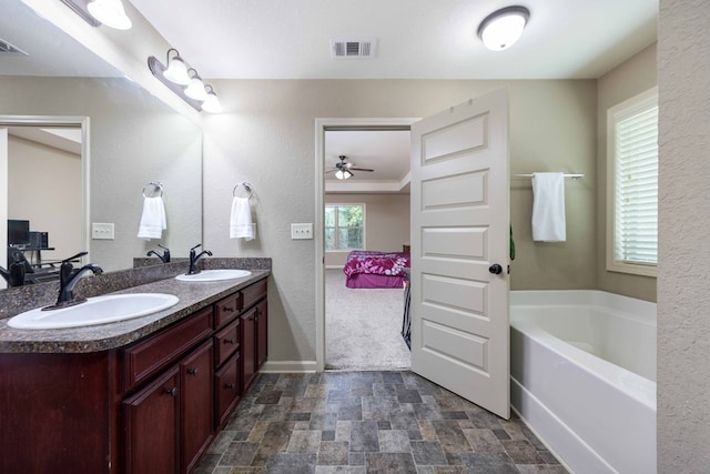 1417 Cloverdale Rd, Columbus, GA 31904 - full bathroom featuring double vanity, stone finish flooring, a bath, and a ceiling fan