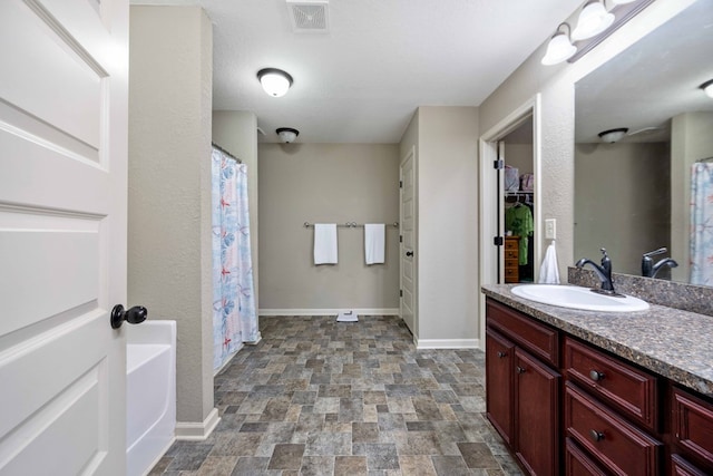 1417 Cloverdale Rd, Columbus, GA 31904 - bathroom with vanity, stone finish flooring, a shower with shower curtain, and a closet