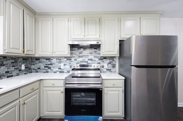 924 Vista Dr, Columbus, GA 31907 - kitchen with white cabinets, under cabinet range hood, stainless steel appliances, light countertops, and tasteful backsplash