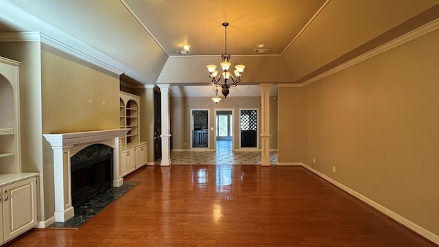 unfurnished living room featuring a high end fireplace, ornamental molding, wood-type flooring, built in features, and a chandelier