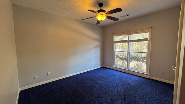 carpeted empty room featuring ceiling fan and a textured ceiling