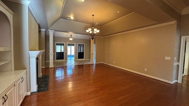 unfurnished living room with decorative columns, crown molding, dark hardwood / wood-style flooring, and a tray ceiling