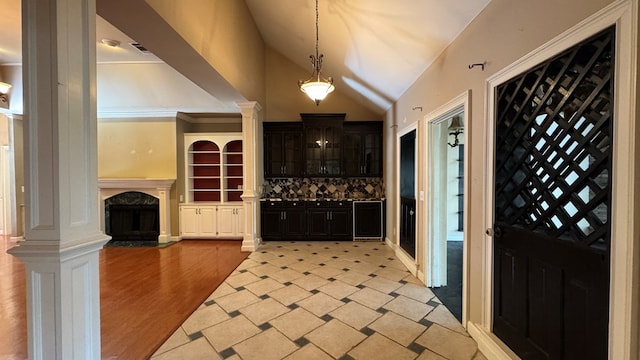 entryway with a premium fireplace, decorative columns, lofted ceiling, and light hardwood / wood-style flooring