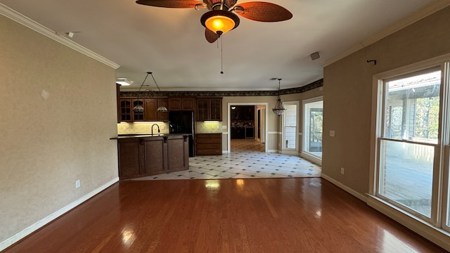 unfurnished living room featuring ceiling fan, light hardwood / wood-style flooring, sink, and ornamental molding