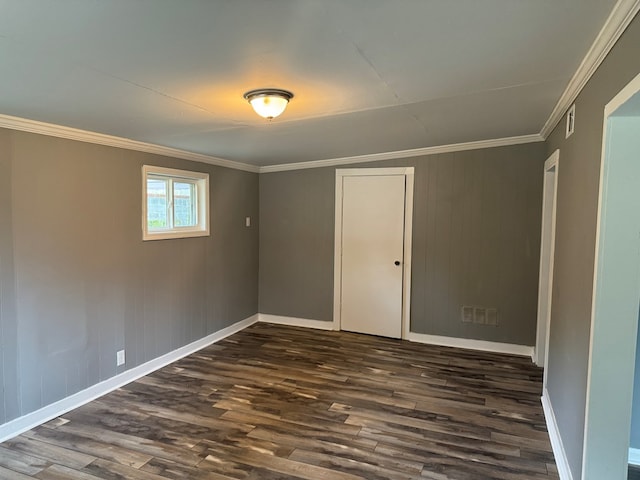 unfurnished room with ornamental molding, dark wood-type flooring, and wood walls