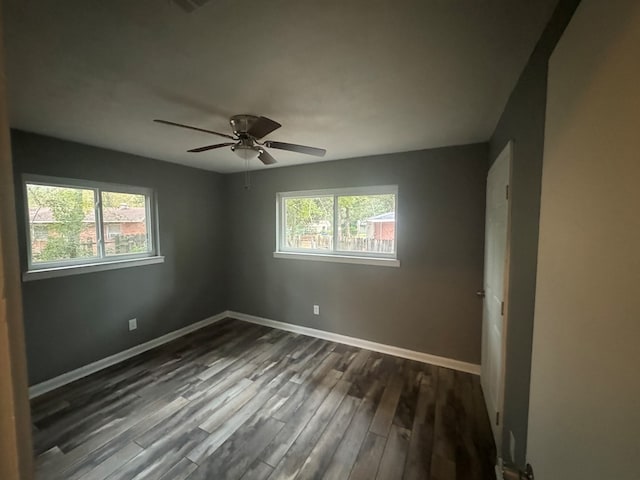 spare room with ceiling fan, a healthy amount of sunlight, and dark hardwood / wood-style floors