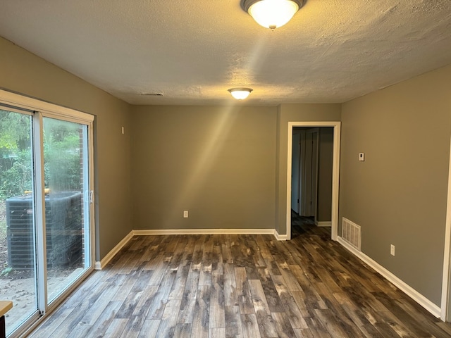 spare room with dark wood-type flooring and a textured ceiling