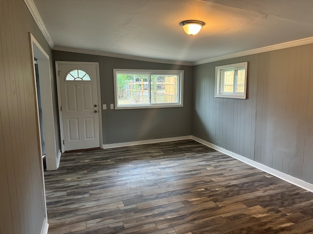 foyer with dark hardwood / wood-style floors, wood walls, lofted ceiling, and ornamental molding