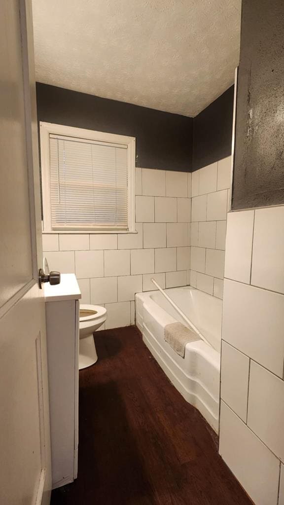 1434 John Smith Ave, Columbus, GA 31903 - full bathroom with a bath, wood finished floors, tile walls, a textured ceiling, and vanity