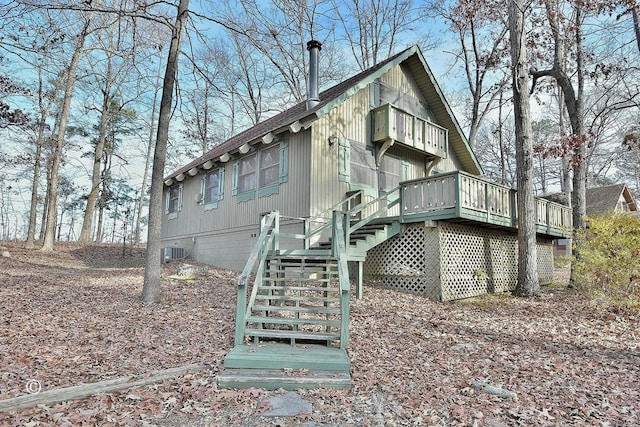 rear view of house featuring central AC and a wooden deck