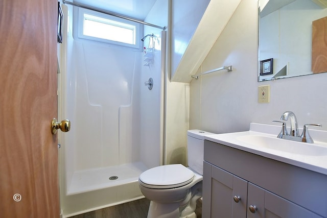 bathroom with walk in shower, hardwood / wood-style floors, vanity, and toilet