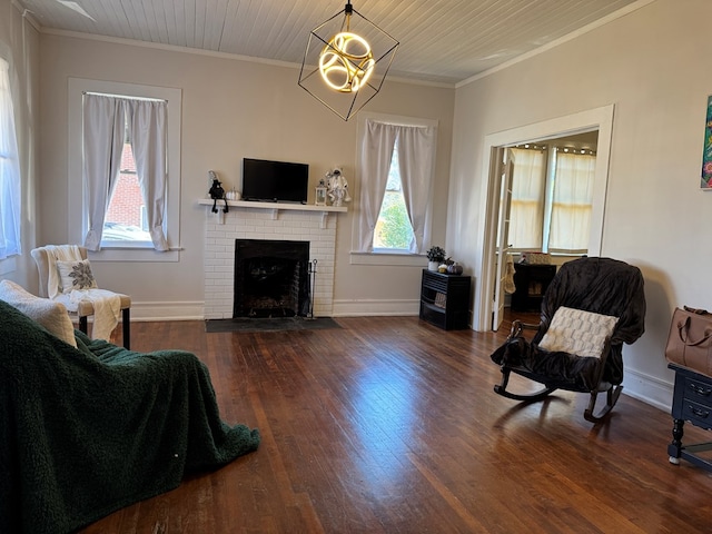 living room with wooden ceiling, dark wood-type flooring, a brick fireplace, crown molding, and a chandelier