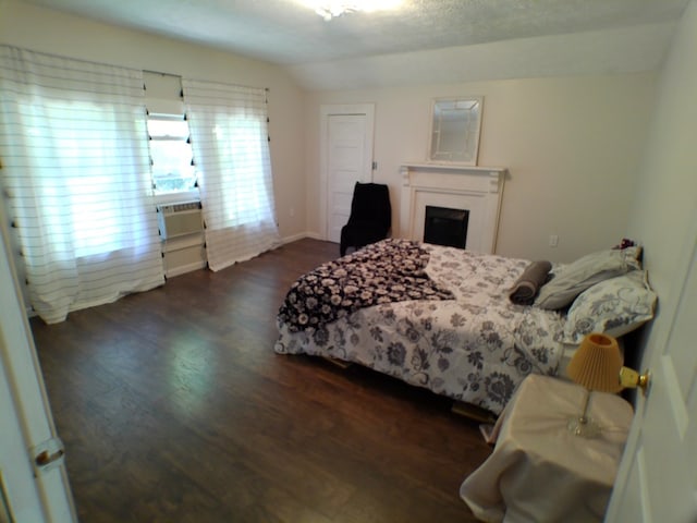 bedroom featuring cooling unit, dark hardwood / wood-style flooring, lofted ceiling, and a textured ceiling