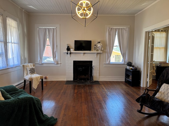 living room featuring plenty of natural light, dark hardwood / wood-style flooring, crown molding, and a fireplace