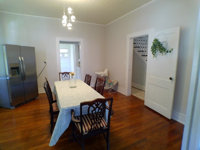 dining area with a notable chandelier, dark hardwood / wood-style flooring, and crown molding