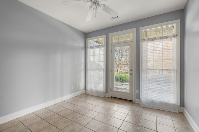 doorway featuring light tile patterned floors, ceiling fan, and plenty of natural light