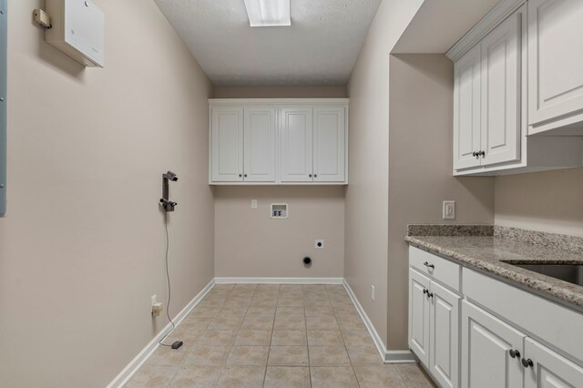 clothes washing area with cabinets, hookup for an electric dryer, light tile patterned floors, washer hookup, and a textured ceiling