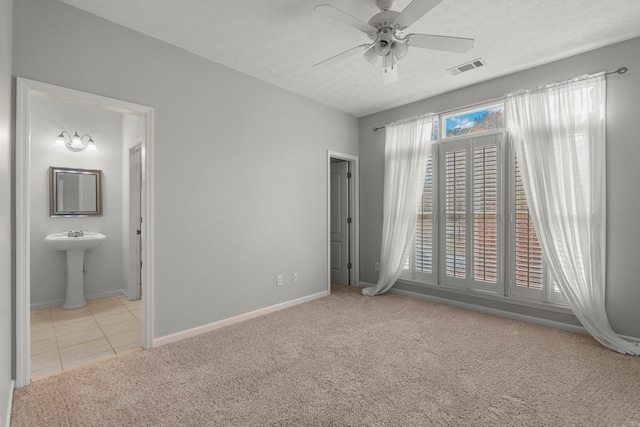 carpeted empty room featuring ceiling fan and a textured ceiling