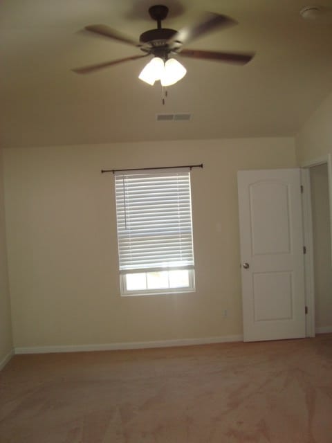 unfurnished room with ceiling fan, light colored carpet, and lofted ceiling