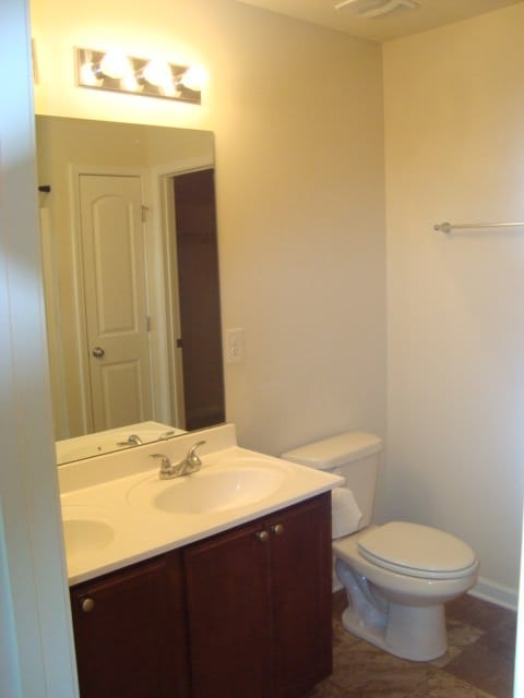 bathroom with toilet, vanity, and tile patterned floors