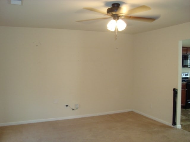 carpeted empty room featuring ceiling fan