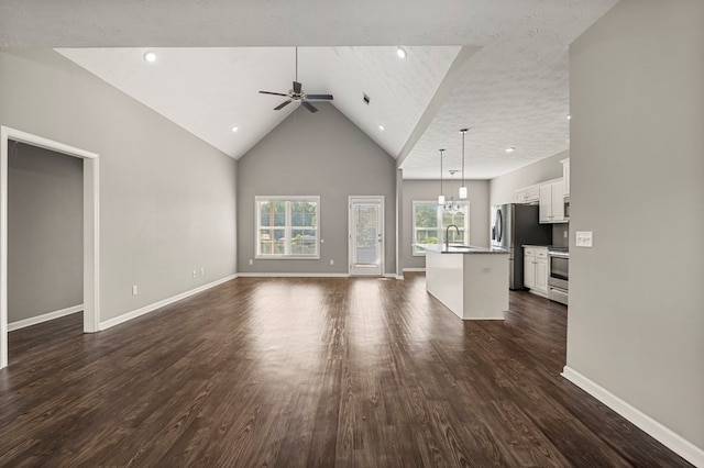 3102 Gatewood Dr, Phenix City, AL 36870 - unfurnished living room featuring a ceiling fan, dark wood-style floors, high vaulted ceiling, a chandelier, and recessed lighting