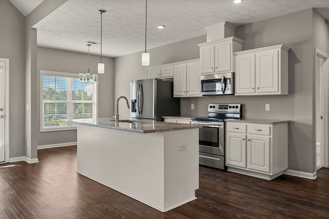 3102 Gatewood Dr, Phenix City, AL 36870 - kitchen featuring appliances with stainless steel finishes, a textured ceiling, a kitchen island with sink, white cabinets, and dark wood-style floors