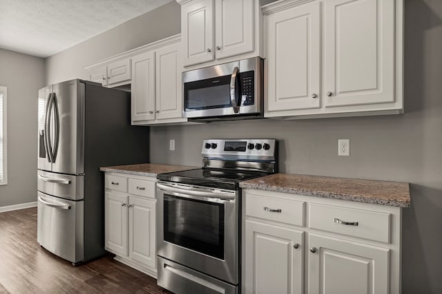 3102 Gatewood Dr, Phenix City, AL 36870 - kitchen featuring stainless steel appliances, dark wood-style floors, white cabinetry, and a textured ceiling
