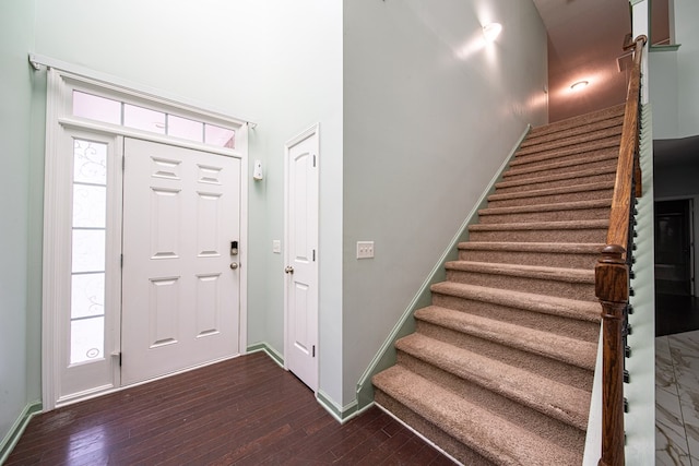 entryway featuring stairs, dark wood finished floors, and baseboards