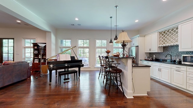 7718 River Crest Dr, Columbus, GA 31904 - kitchen featuring dark countertops, appliances with stainless steel finishes, open floor plan, a breakfast bar area, and a sink