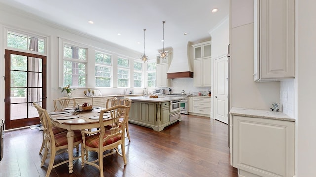 7718 River Crest Dr, Columbus, GA 31904 - kitchen with custom range hood, tasteful backsplash, dark wood finished floors, ornamental molding, and a center island