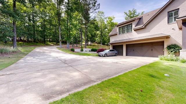 7718 River Crest Dr, Columbus, GA 31904 - view of side of home with concrete driveway, a garage, stucco siding, and a yard