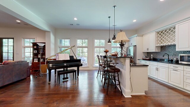 7718 River Crest Dr, Columbus, GA 31904 - kitchen featuring dark countertops, appliances with stainless steel finishes, open floor plan, a breakfast bar area, and a sink