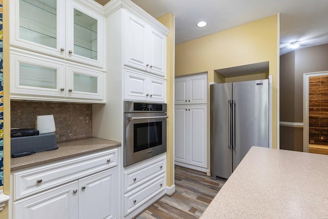 175 Slaughter Dr, Waverly Hall, GA 31831 - kitchen featuring stainless steel appliances, white cabinets, wood finished floors, tasteful backsplash, and light countertops