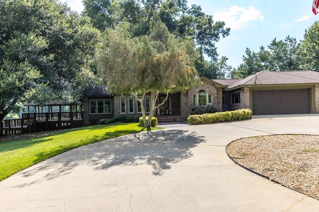 175 Slaughter Dr, Waverly Hall, GA 31831 - view of front facade featuring curved driveway, a front yard, an attached garage, and brick siding