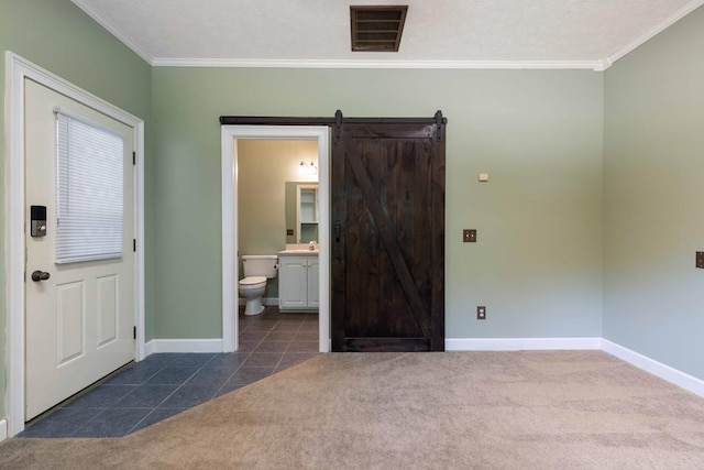 175 Slaughter Dr, Waverly Hall, GA 31831 - unfurnished room featuring crown molding, a barn door, dark tile patterned floors, and dark carpet
