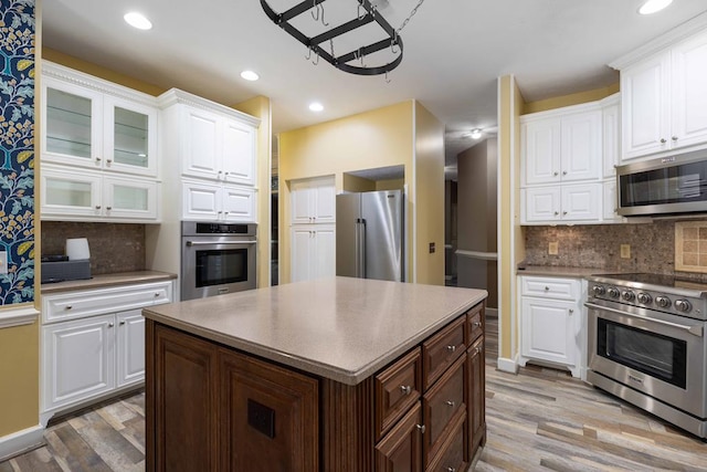 175 Slaughter Dr, Waverly Hall, GA 31831 - kitchen with stainless steel appliances, light wood-style floors, white cabinetry, backsplash, and glass insert cabinets