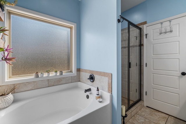 bathroom with a garden tub, a shower stall, and tile patterned flooring