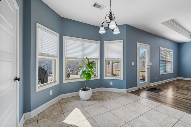 interior space with a notable chandelier, visible vents, and baseboards